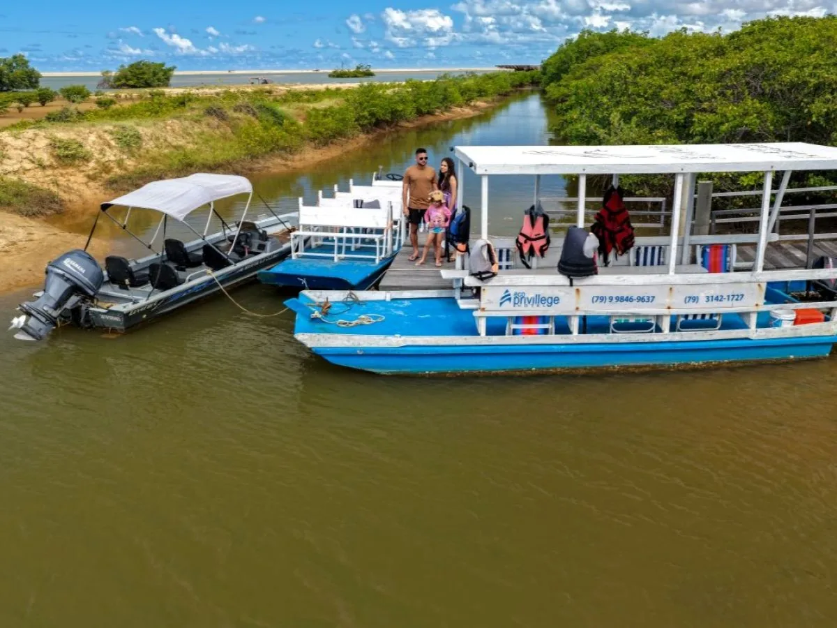 Vista aérea dos barcos atracados no canal, com dunas ao fundo